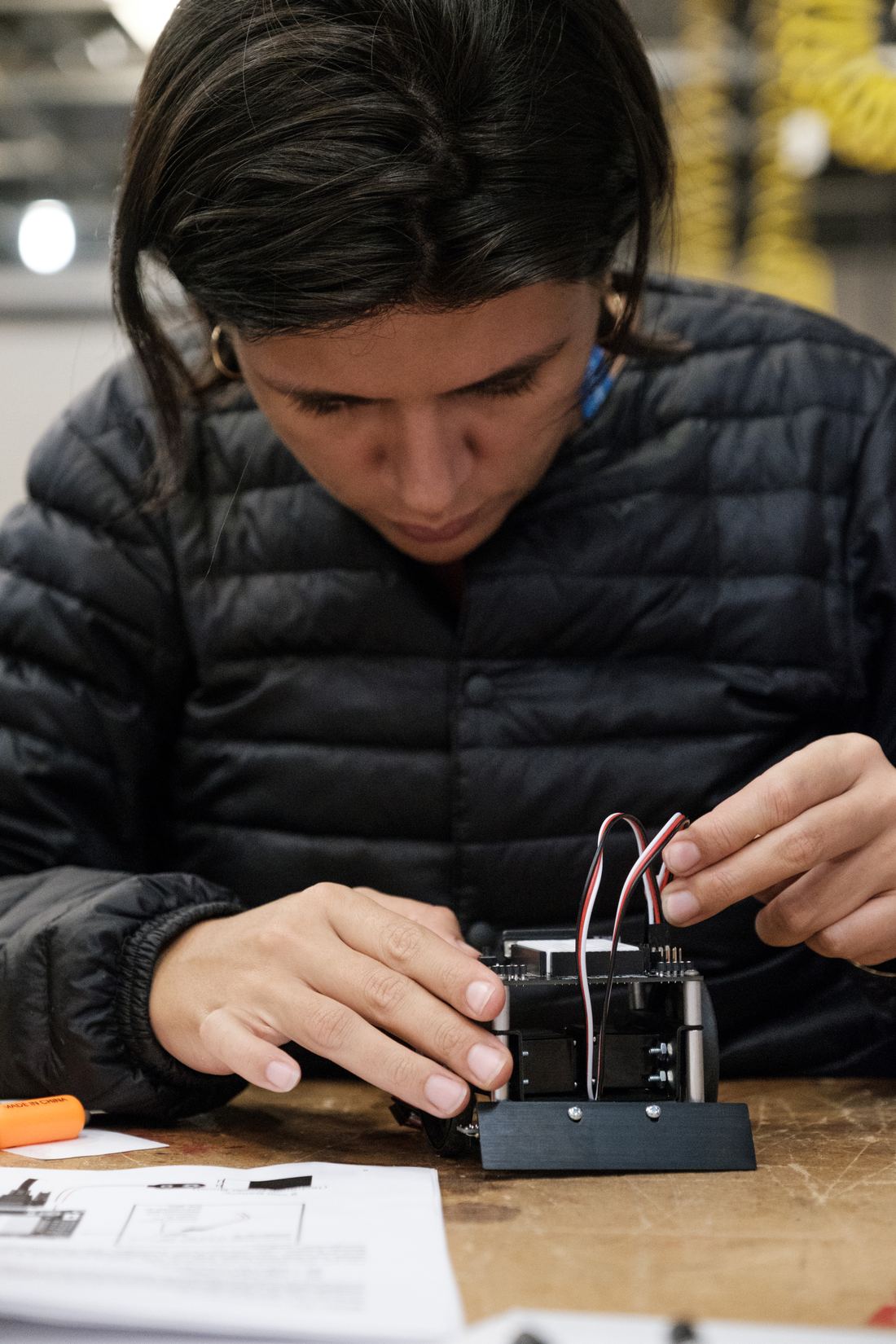 Anna montando um protótipo de hardware na bancada